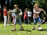 Bild zeigt zwei Kinder beim Wettrennen mit Holzschuhen.