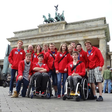Jugendliche in roten Jacken stehen vor dem Brandenburger Tor.