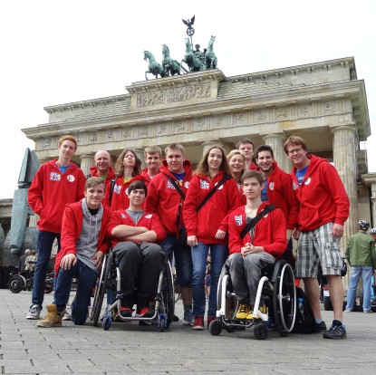 Jugendliche in roten Jacken stehen vor dem Brandenburger Tor.