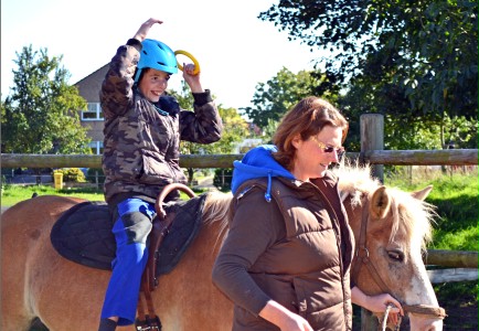 Junge reitet auf einem Pferd und macht Übungen