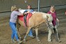 JUnge liegend auf Pferd