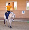 Junge reitet freihändig auf einem Pferd
