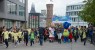 Kinder laufen mit zwei Maskottchen und Banner durch Köln.