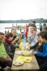 Frauen und Männer sitzen an einem See an einem Tisch