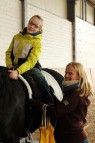 Der zwölfjährige Lee sitzt auf dem schwarzen Hengst und streichelt ihn. 