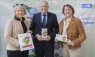 Zwei Frauen und ein Mann mit Programmheften in der Hand.