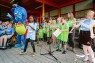 Kinder singen. LVR-Inklusionsbotschafter Mitmän steht im Hintergrund und tanzt . 