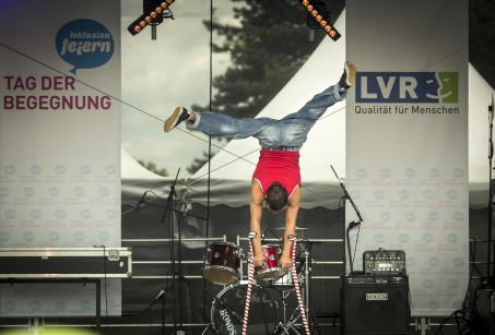 Ein Artist macht auf Krücken einen Handstand