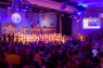 Man sieht viele verkleidete Menschen in einem Festsaal. 