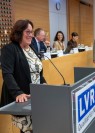 Man sieht eine dunkelhaarige Frau, die an einem LVR-Rednerpult steht. 