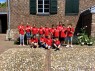 Man sieht eine Gruppe Schüler*innen in roten T-Shirts vor dem LVR-KULTURHAUS Landsynagoge Rödingen.