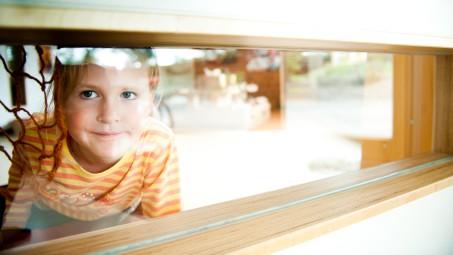 Ein Kind schaut durch eine Scheibe.
