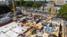 Man sieht eine große Baustelle mit zwei Krähnen. Im Hintergrund sieht man den Deutzer Bahnhof. 