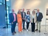 Sechs Personen stehen nebeneinander vor drei Ausstellungsplakaten und lächeln in die Kamera.