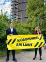 LVR-Direktor Dr. Georg Lunemann und LVR-Direktorin Ulrike Lubek halten ein gelbes Transparent mit der Schrift "Kommunen am Limit".