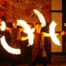 Feuershow mit zwei Künstlern, die Feuerstäbe jonglieren.