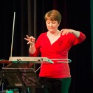 Eine Frau die auf der Bühne ein Theremin spielt.