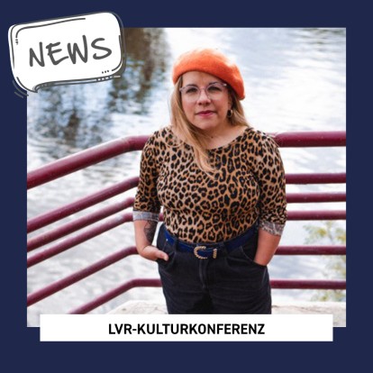 Eine Frau mit langen blonden Haaren blickt in die Kamera. Sie trägt eine Brille, eine rote Baskenmütze und ein Shirt mit Leopardenprint.