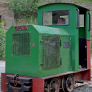 Eine Steinbruchbahn mit Lokführer auf den Gleisen während der fahrt.