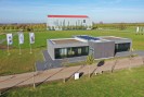 Foto: Blick auf eine grauen Pavillon im Gelände, im Hintergrund das LvR-Römermuseum