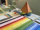 Foto: Bunte, aufgefächerte Papiere auf einem Tisch.