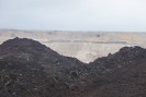 Foto: geschichteter Haufen, im Hintergrund Tagebau sichtbar