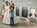 Foto: zwei Kinder und ein erwachsener Mensch an einer Furine im weißen Kleid