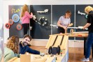 Foto: mehrere Erwachsene arbeiten an unterschiedlichen Aufgaben