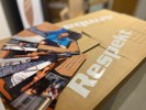 Foto: mehrere Flyer gefächert auf einem Karton mit der der Aufschrift Respekt