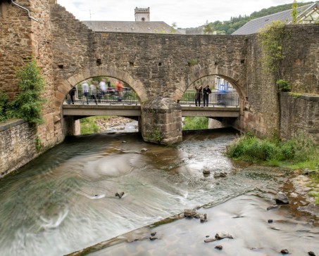 Durchfluss der Erft im Bereich der Stadtmauer von Bad Münstereifel. Die beiden Rundbögen sind Teil der ehemaligen Schoßpforte, dahinter führt die Werkbrücke über die Erft; Foto: Marcel Zanjani / LVR