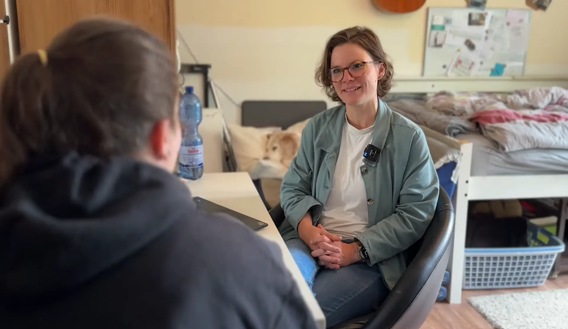 Dr. Julia Göbel-Erkan sitzt in einem Wohnzimmer und spricht mit ihrer Patientin.