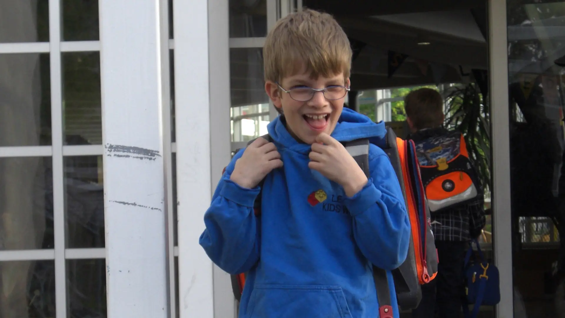 Inklusion trotz Sehbehinderung: Kind mit Brille geht allein aus dem Schulgebäude