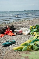 Das Bild zeigt einen Ostseestrand. Im Vordergrund ist Müll zu sehen, der den Strand bedeckt