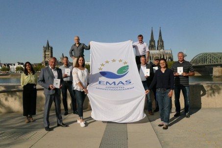 Umweltdezernent Detlef Althoff und Auszubildende Sina Mieseler (vorne links) mit Mitgliedern des Umweltmanagement-Teams zeigen die EMAS-Flagge mit dem Kölner Dom im Hintergrund. Foto: Megan Unger / LVR