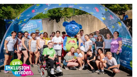 Kinder und Jugendliche, die unter einem großen Banner stehen und ihren Pokal hochhalten