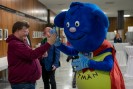 Das blaue Mitm&auml;n Maskottchen und ein Teilnehmer geben sich ein High Five
