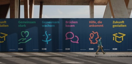 Man sieht eine Plakatwand mit sechs Plakaten des LVR. Die Plakate sind dunkelblau. Darauf steht in gelb, grün, hellblau, pink, rot und gelb "Zukunft gestalten", "Gemeinsam stark", "Gemeinsam wachsen", "Brücken bauen", "Hilfe, die ankommt" und "Zukunft gestalten". Zudem sind auf den Plakten jeweils Piktogramme eines Doktorhuts, einer geöffneten Hand über der ein Herz schwebt, einem lächelnden Smiley, dem sogenannten Friendly Face, zwei Sprechblasen, dem Umriss von NRW sowie erneut dem Doktorhut zu sehen. In der linken unteren Ecke ist das LVR-Logo in Weiß zu sehen. In der rechten unteren Ecke steht der Claim "Qualität für Menschen".