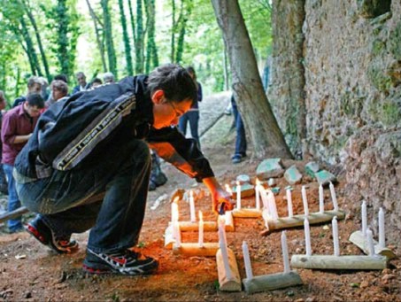 Jugendlicher entzündet Kerzen unter einem Baum