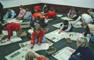 Viele Schulkinder sitzen auf dem Boden und malen