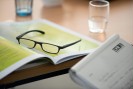 Kongressunterlagen, das Bild zeigt Kongressunterlagen mit Brille, Block und Wasserglas