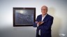 Foto: Dr. Achim Sommer steht vor einem Kunstwerk