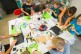 Foto: Kinder sitzen um einen Tisch herum und bedienen Tablets