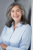 Eine Frau lacht in die Kamera.