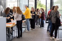 Eine Gruppe von Menschen, die sich am Tagungsbüro zur Kulturkonferenz anmelden.