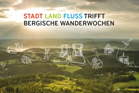 Landschaft mit Wäldern und Feldern im Gegenlicht, aufgenommen aus der Vogelperspektive. Im Himmel steht Schrift: Stadt Land Fluss trifft Bergische Wanderwochen