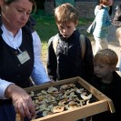 Frau in Tracht und Kinder, die Apfelringe auf einem Sieb trocknen