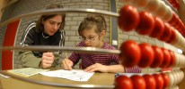 Mädchen mit Lehrerin vor einem Übungsblatt