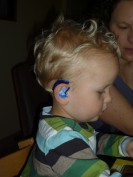 Bild zeigt kleines Kind mit Hörhilfe