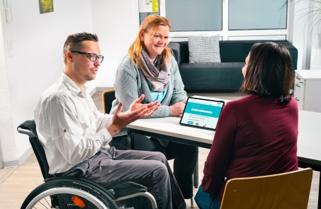 Zwei Menschen beraten eine Frau.