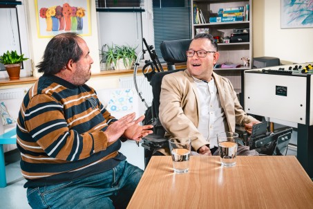 Ein Mensch mit Behinderung berät einen Menschen mit Behinderung.